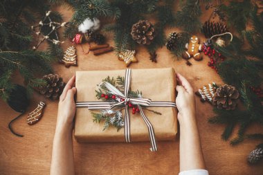 Tarz sahibi köylü noel hediyeleri ve çam dalları tutan eller.