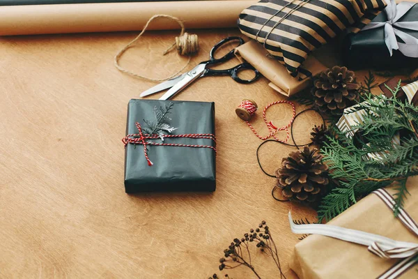 Stylowe pudełko świąteczne w czarnym papierze z gałązką sosny i s — Zdjęcie stockowe