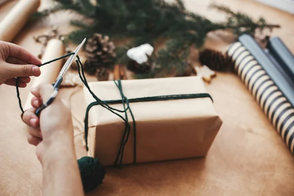 손으로 소박 한 크리스마스 선물을 포장하고, 녹색 쌍둥이를 자르고 , P. — 스톡 사진