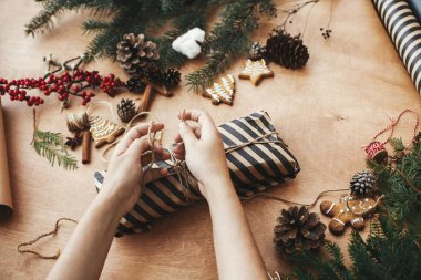 Kırsal Noel hediyesini paketliyorum. Noel hediyesini paketleyen eller