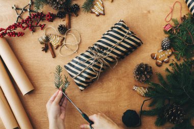 Kırsal Noel hediyesini paketliyorum. Noel hediyesini paketleyen eller