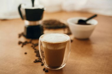 Roa 'nın arka planında cam bardakta köpüklü Latte veya cappuccino