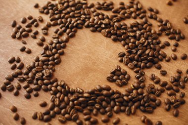 Kahve fincanı ahşap masada kavrulmuş kahve çekirdeklerinden yapılmış. Ben...