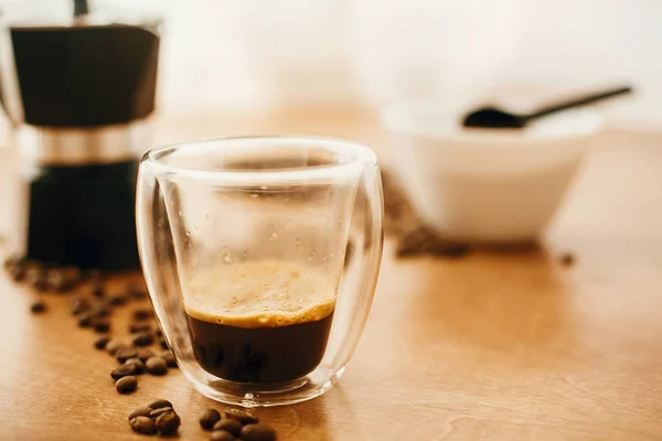 Espresso caliente en taza de vidrio, granos de café tostados, café molido —  Fotos de Stock