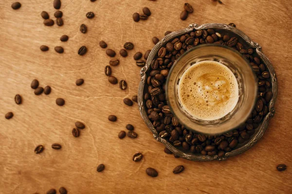 Hot espresso with foam in glass cup on vintage plate with aromat — 스톡 사진