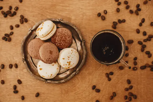 Kaffee in Glasbecher und köstliche Macaron-Kekse auf Vintage Pla — Stockfoto