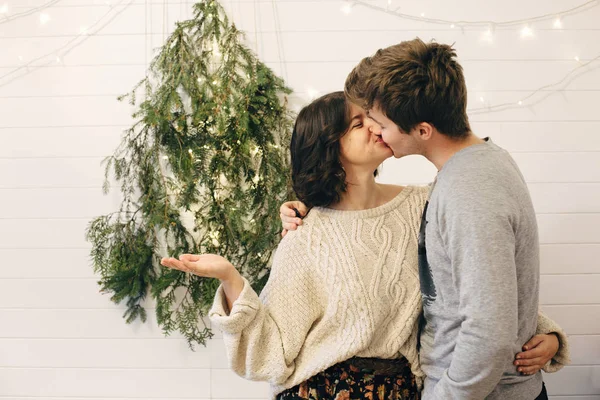 Feliz pareja hipster divirtiéndose y besándose en la Navidad moderna —  Fotos de Stock