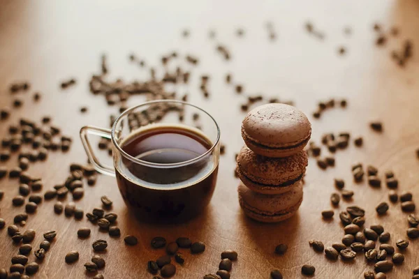 Kaffee in Glasbecher und köstliche Makronenkekse auf Holzlasche — Stockfoto
