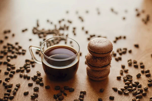 Coffee in glass cup and delicious macaroon cookies on wooden tab — 스톡 사진