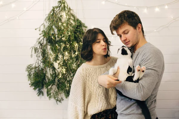 Pasangan hipster bahagia memegang kucing, bersenang-senang dan berciuman di chri — Stok Foto