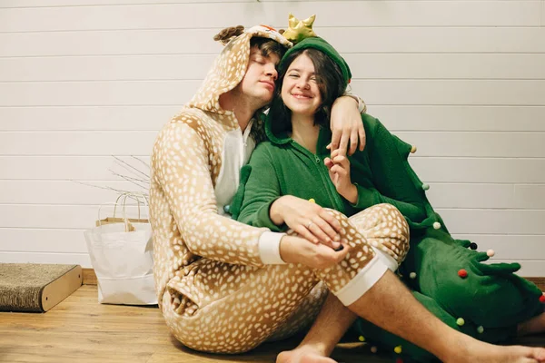 Счастливая пара в праздничной пижаме, веселясь за новогодними подарками — стоковое фото
