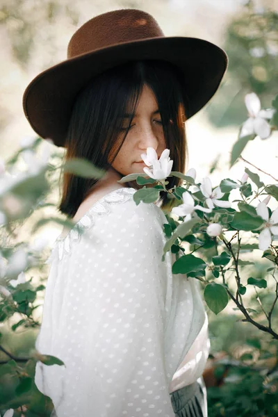 Sensual portrait of beautiful hipster woman in hat smelling  whi — Stock Photo, Image