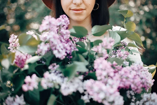 Şapkalı güzel bir kadının şehvetli portresi. Elinde leylak fl var. — Stok fotoğraf