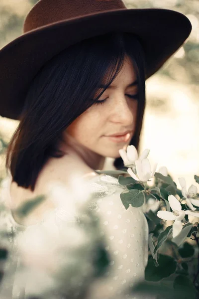 Sensual portrait of beautiful hipster woman in hat smelling  whi — Stock Photo, Image