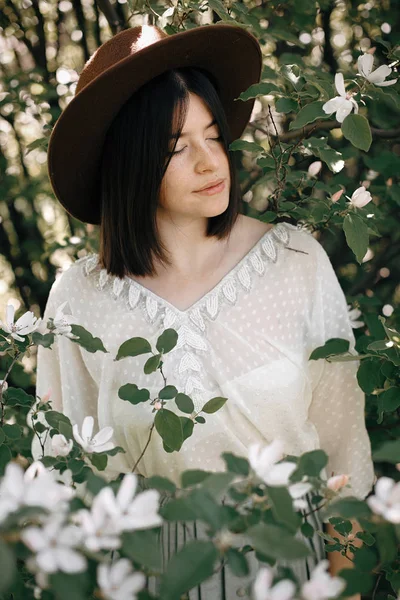 Ruhiges Porträt der schönen Hipster-Mädchen, die in weißen Blüten steht — Stockfoto