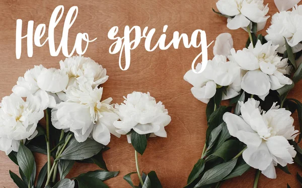 Hello spring text on stylish white peony flat lay on rustic wood — Stock Photo, Image