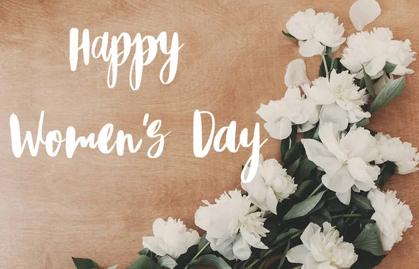 Happy women 's day tekst op witte pioenroos plat lag op rustieke houten — Stockfoto
