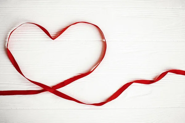 Corazón de cinta roja sobre fondo blanco de madera con espacio para texto . —  Fotos de Stock