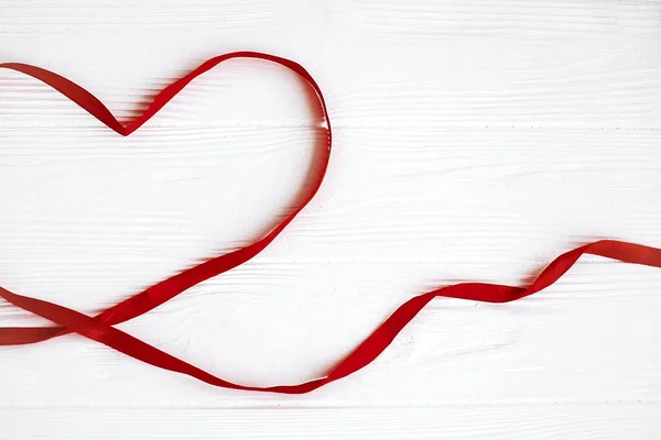 Corazón de cinta roja sobre fondo blanco de madera con espacio para texto . —  Fotos de Stock