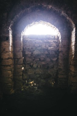 Ukrayna 'daki Chortkiv kalesinin kalıntılarının içinde. Ortaçağ kalesinin karanlık odalarında yıkılmış tuğla duvarlar ve pencere ışığı, Avrupa 'nın tarihi savunma kalesi.