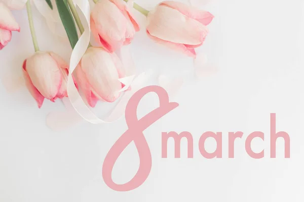 3月8日 幸せな女性の日の挨拶カード 白の背景にリボンでピンクのチューリップに8行進テキスト フラットレイ スタイリッシュな柔らかいイメージ 手書き文字 国際女性デー — ストック写真