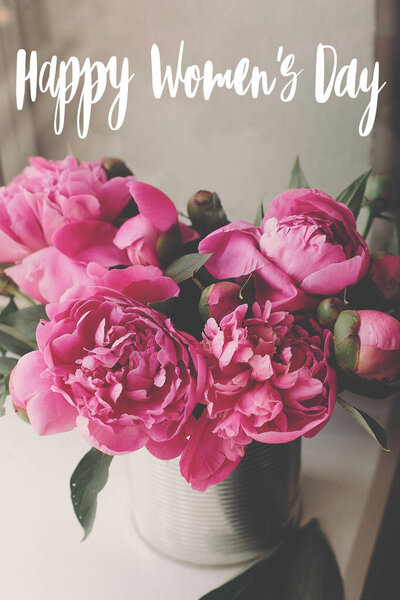 Happy Women's day text. Happy Women's day lettering on rustic stylish pink peonies . Floral greeting card.  Beautiful peony flowers, tender image. 8 march