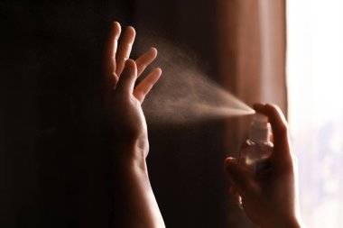 Dezenfekte eden eller. Grip veya koronavirüsü önlemek için ellerinde antiseptik sprey kullanan biri. Kişisel hijyen. Ellerini nasıl temizleyeceğini.
