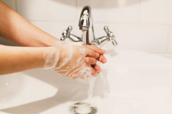 在水龙头流出的水的背景上用肥皂泡沫洗手 预防流感 个人卫生 如何正确地洗手 — 图库照片