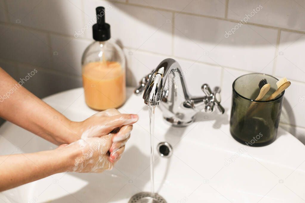 Washing hands. Hands washing with soap foam on background of flowing water in bathroom. Rubbing palms. Prevention of flu disease. Personal hygiene. Cleaning hands to prevent coronavirus epidemic