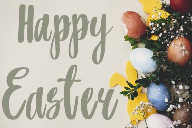 Mutlu Paskalya metinleri. Paskalya tebrik kartı. Şık paskalya yumurtaları, sarı tavşancık, sarı kağıtta bahar çiçekleri. Doğal boyanmış paskalya yumurtaları ve tavşan süsü. Tatil kartı