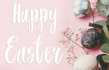 Mutlu Paskalya metinleri. Paskalya tebrik kartı. Şık paskalya yumurtaları, bahar çiçekleri, pembe kağıtta okaliptüs dalı. Modern doğal boyanmış mavi ve mermer paskalya yumurtaları. Tatil kartı