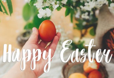 Mutlu Paskalya metinleri. Paskalya tebrik mektupları. Çağdaş Paskalya yumurtası, çiçek açan kiraz çiçeklerinin arka planında. Şık kırmızı yumurta. Tebrik kartı