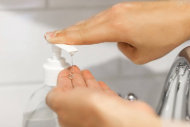 Dezenfekte eden eller. Şişedeki dezenfeksiyon için avuç içine alkol jeli sürüyorum. Koronavirüsü önlemek için ellere antibakteriyel sabun sürmek. Ellerini düzgün bir şekilde temizleyip dezenfekte etmek.