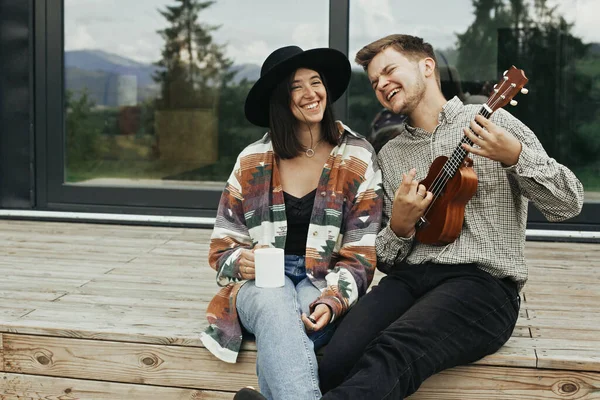 Hipster Férfi Játszik Ukulele Elegáns Pihentető Tornácon Modern Kabin Nagy — Stock Fotó