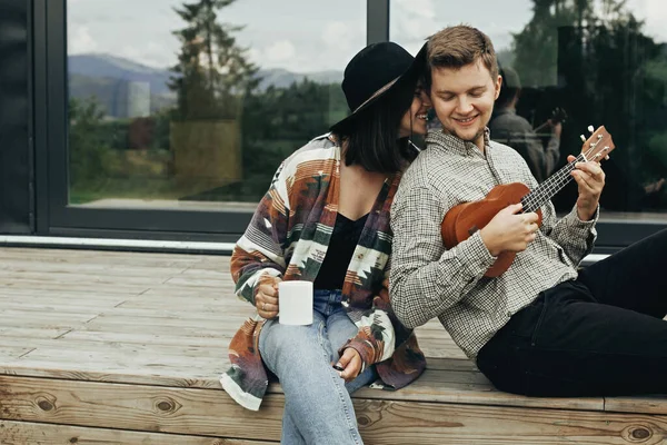 Happy Hipster Couple Relaxing Wooden Porch Modern Cabin Big Windows — Stock Photo, Image
