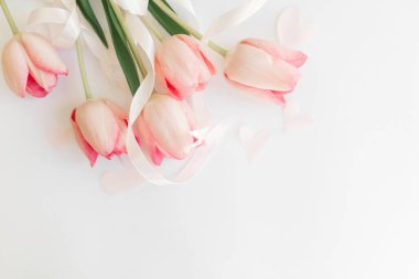 Kurdeleli pembe laleler ve beyaz arkaplanlı kalpler. Yumuşak bahar görüntüsü. Mutlu kadınlar günü. Mesaj için yeri olan tebrik kartı modeli. Anneler Günün kutlu olsun. Merhaba bahar.