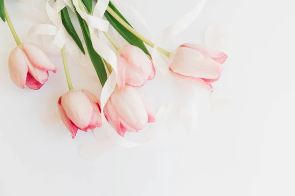 女人快乐的一天 粉红的郁金香 带着丝带 心形白色背景 时尚柔软的春天图像 贺卡上有文字的空白处 母亲节快乐 你好春天 — 图库照片