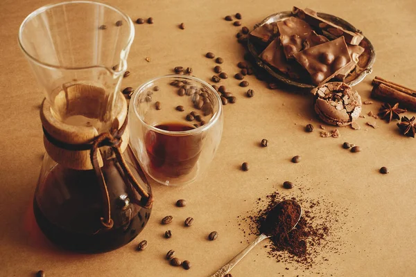 新鮮なコーヒー ローストビーンズ スプーンでグラウンドコーヒー フィルターコーヒーとマカロン チョコレートとシナモンのためのガラスフラスコ茶色の背景にあるガラスカップ コーヒーの基本 — ストック写真