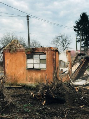 Kazıcı kırsaldaki tuğla evi yok ediyor. Buldozer eski tuğlalardan toprak ve çöplerle dolu duvarlardan beton topluyor. Kazma makineleri evi mahvediyor