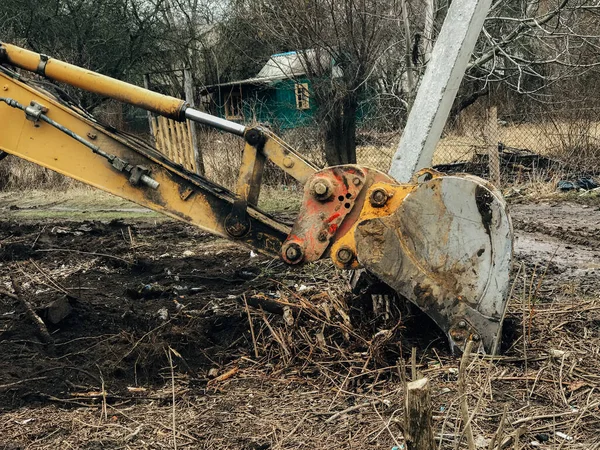 田舎の土地で木を根こそぎにする掘削機 古い木 根や汚れやゴミと枝からブルドーザークリア土地 バックホーの機械 庭仕事 — ストック写真