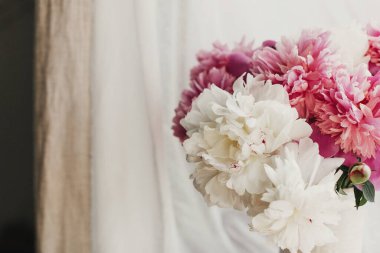 Vazoda pembe ve beyaz şakayıklar. Merhaba bahar. Kırsal ahşap pencere pervazında güneşli bir ışıkta hoş bir şakayık buketi. Anneler Günün kutlu olsun. Sevgililer günün kutlu olsun.