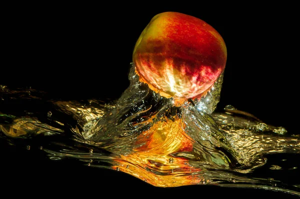 Äpfel in Wasser mit Spiegelung und Spritzer Stockbild