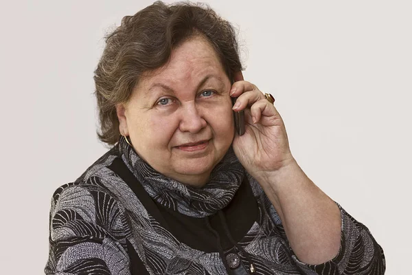 Starší žena s úsměvem mluvit na telefonu — Stock fotografie