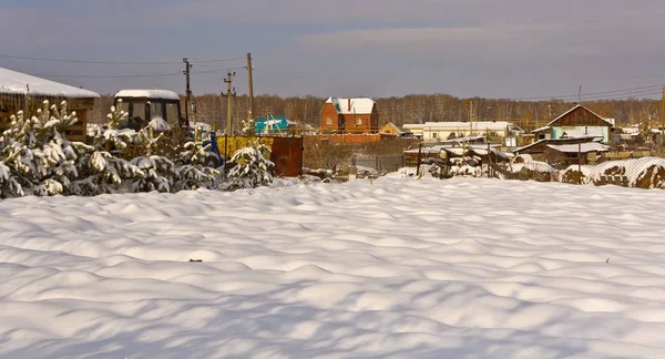 Kar, güneş tarafından aydınlatılmış kaplı köydeki büyük arsa