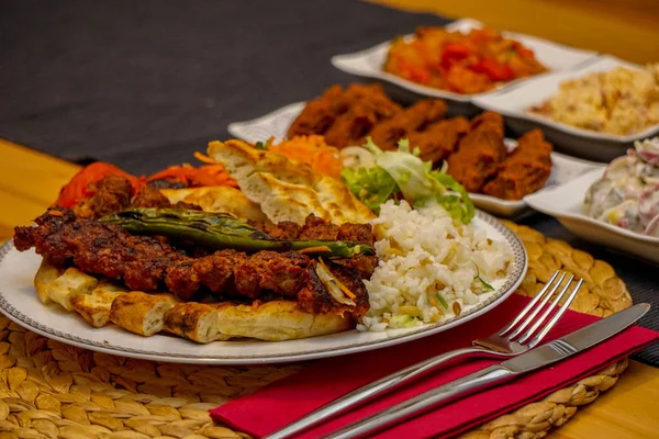 Türk Kebap ve çeşit çeşit meze ahşap masa samimi görüntü üzerinde