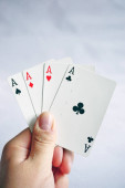Poker karty s různými kombinacemi v mužské ruce zblízka a izolované pozadí
