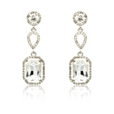 Çift üzerinde beyaz izole gümüş elmas küpe