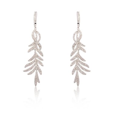 Çift üzerinde beyaz izole gümüş elmas küpe