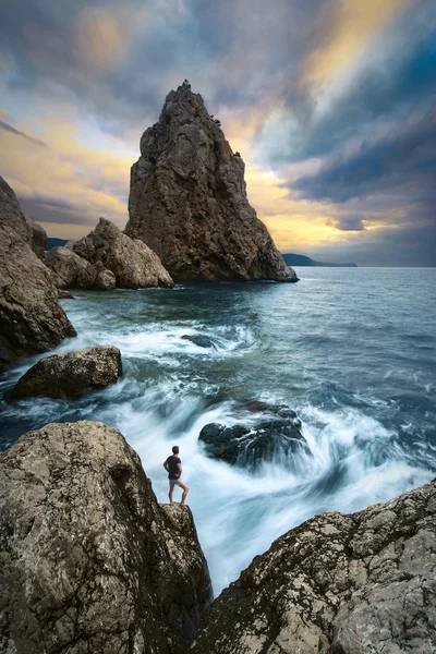 L'uomo su un bordo di scogliere sopra il mare — Foto Stock