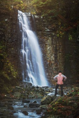 Şelale önünde duran uzun yürüyüşe çıkan kimse